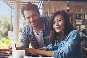 Two people on a laptop banner